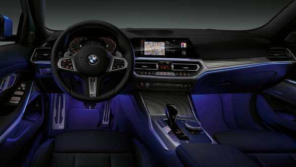 BMW serije 3 Limuzina, Ambijentalno osvjetljenje Prednji pogled na kokpit vozača BMW-a serije 3 Limuzina s Ambijentalnim svijetloplavim osvijetljenjem prostora za noge.