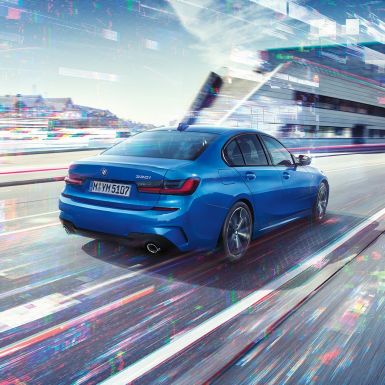 BMW serije 3 Limuzina, stražnji bočni prikaz. Tročetvrtinski prikaz stražnjeg kraja BMW-a serije 3 Limuzina tokom dana ispred urbane scene.