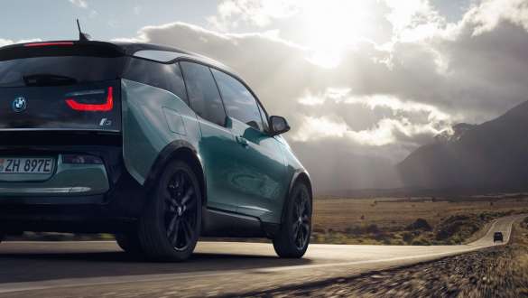 Tročetvrtinski prikaz stražnjeg kraja BMW-a i3 2018 u vožnji na autocesti Tročetvrtinski prikaz stražnjeg kraja BMW-a i3 I01 2018 Jucaro bež boje s Frozen Grey metalik detaljima u vožnji autocestom