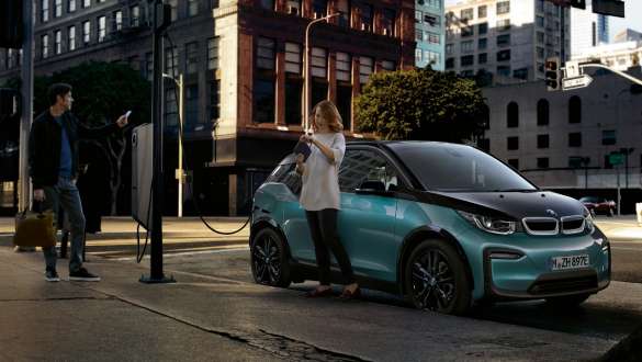 BMW i3 2018 na javnoj stanici za napajanje Par napaja svoj BMW i3 I01 2018 Jucaro bež boje s Frozen Grey metalik detaljima na javnoj stanici za napajanje