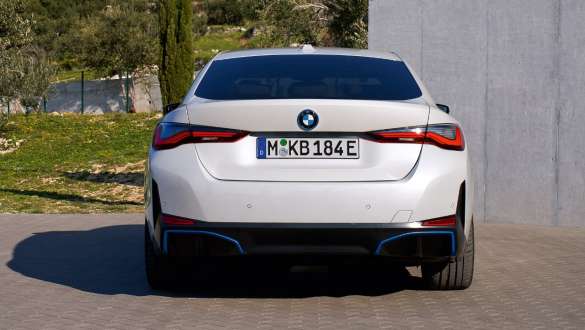 Pogled straga BMW i4 eDrive40 G26 2021 na parkingu BMW i4 eDrive40 G26 2021 Mineral White pogled straga na parkingu