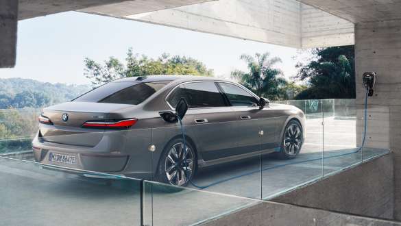 BMW i7 Limuzina G70 BMW 3/4 pogled straga punjenje kod kuće BMW i7 Limuzina G70 BMW Individual Oxid grey metalik 3/4 pogled straga punjenje kod kuće s Wallboxom