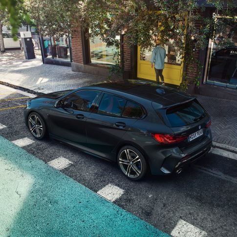BMW M135i xDrive, parkiran. BMW M135i xDrive u Black Sapphire metalik boji, parkiran, ptičja perspektiva bočne strane.