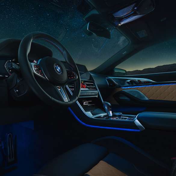 BMW M8 Competition Coupé, unutrašnjost. BMW M8 Competition Coupé, unutrašnjost noću sa M kožnim upravljačem i plavim ambijentalnim osvjetljenjem.
