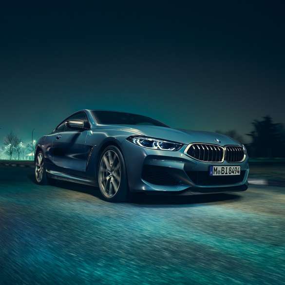 BMW M850i xDrive Coupé, tročetvrtinski prednji lijevi pogled. BMW M850i xDrive Coupé u Barcelona Blue metalik, tročetvrtinski prednji lijevi pogled, vožnja noću.