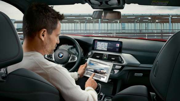 BMW Connected. BMW X4 M Automobili, BMW Connected, žena s osvijetljenim globusom u ruci.