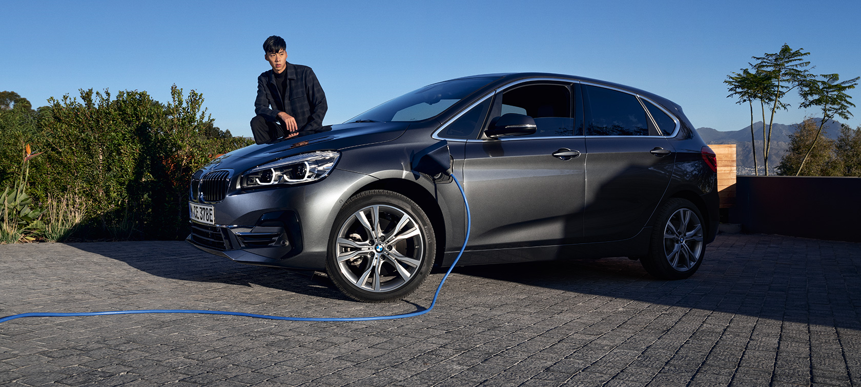 Tročetvrtinski bočni prikaz plug-in hibrida BMW-a 225xe Active Tourer na napajanju s modelom Tročetvrtinski bočni prikaz plug-in hibrida BMW-a225xe Active Tourer na napajanju