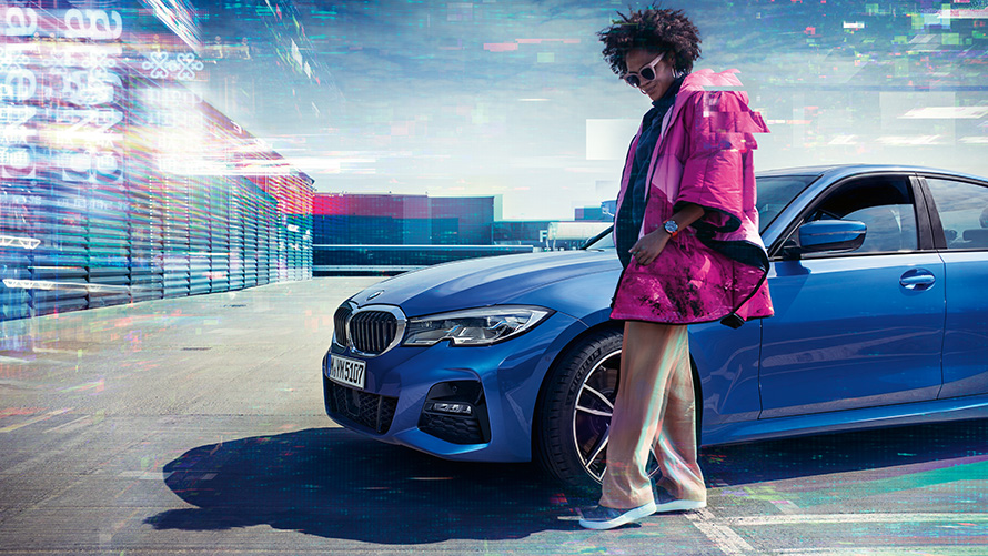 BMW serije 3 Limuzina (G20), Portimao blue metalik, 7/8 sprijeda BMW serije 3 Limuzina (G20), Portimao blue metalik, 7/8 sprijeda na parkingu s osobom u prvom planu