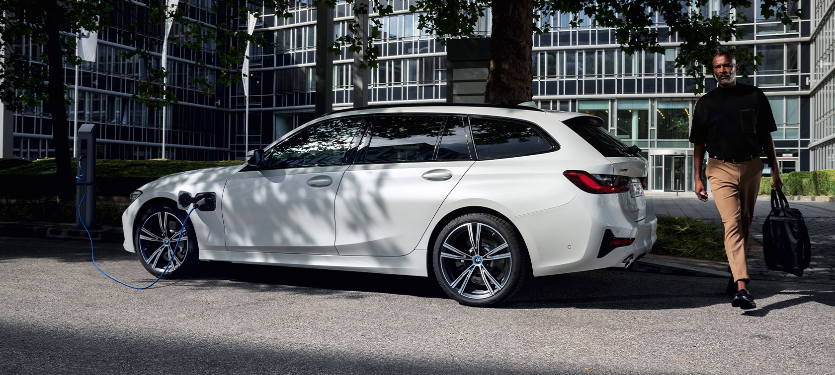 Tročetvrtinski bočni prikaz plug-in hibrida BMW-a serije 3 Touring 2021 G21 na napajanju Tročetvrtinski bočni prikaz plug-in hibrida BMW-a serije 3 Touring 2021 G21 na napajanju s modelom