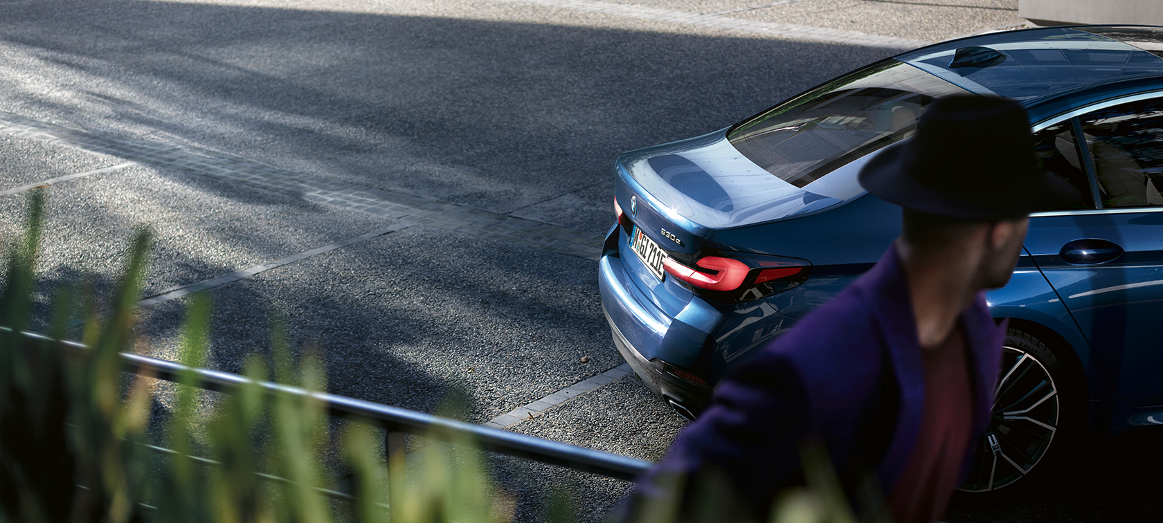 Muškarac stoji pokraj parkiranog BMW-a BMW serije 5 limuzina G30 BMW serije 5 limuzina G30 Facelift 2020 muškarac stoji pokraj parkiranog BMW-a