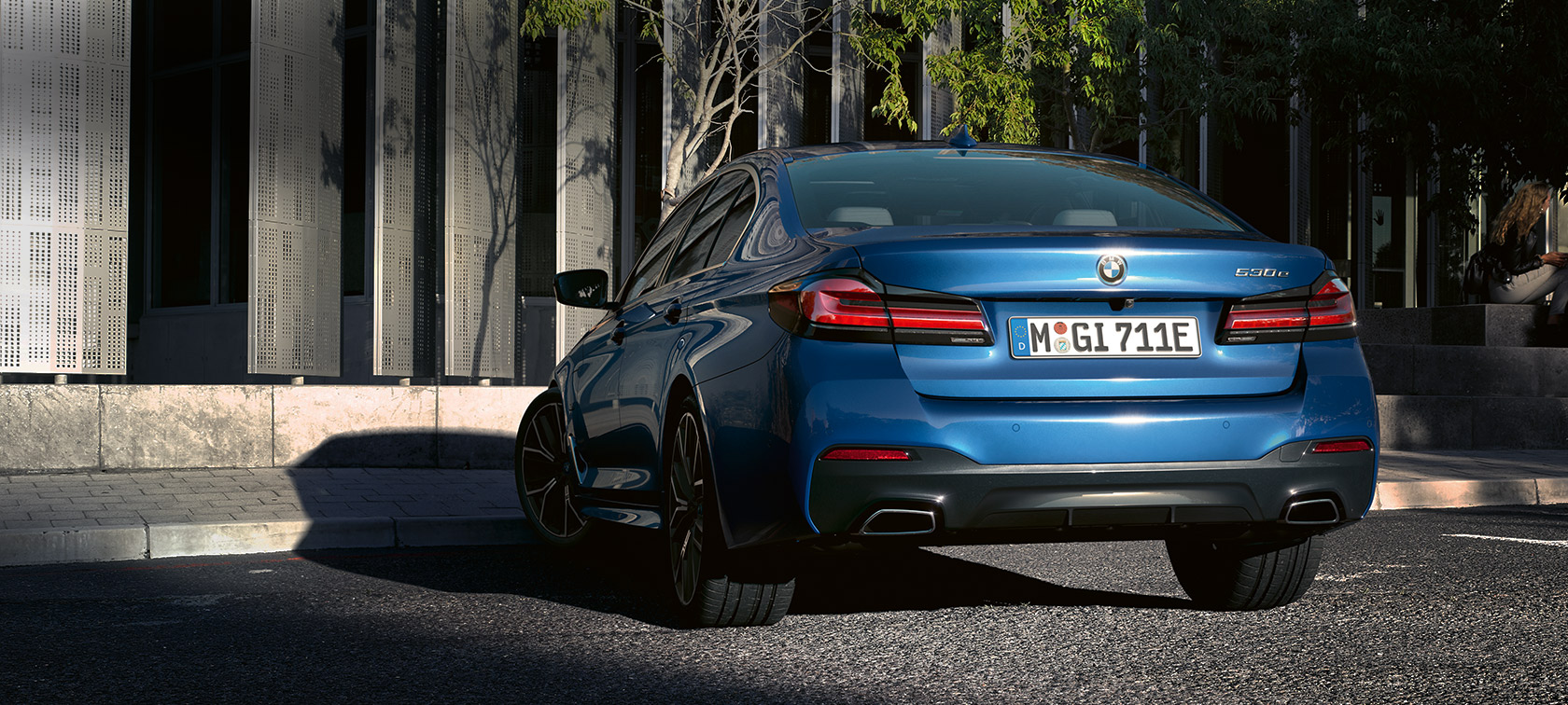 BMW serije 5 Limuzina eDrive (G30) Phytonic Blue metalik BMW serije 5 Limuzina eDrive (G30) Phytonic Blue metalik, stražnji prikaz parkiran ispred zgrade