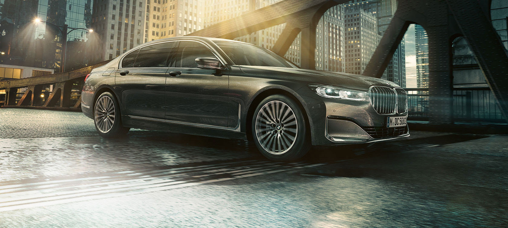 BMW serije 7 Limuzina u bočnom prikazu BMW serije 7 Limuzina u bočnom prikazu s otvorenim vratima ispred osvjetljenog hotela