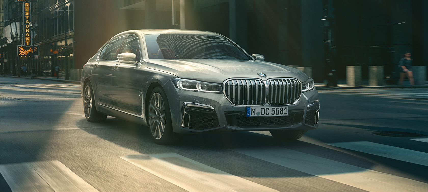 BMW serije 7 limuzina G11 G12 2019 Bernina Grey Amber Effect tročetvrtinski pogled sprijeda u vožnji BMW serije 7 limuzina G11 G12 2019 Bernina Grey Amber Effect tročetvrtinski pogled sprijeda u vožnji urbanom sredinom
