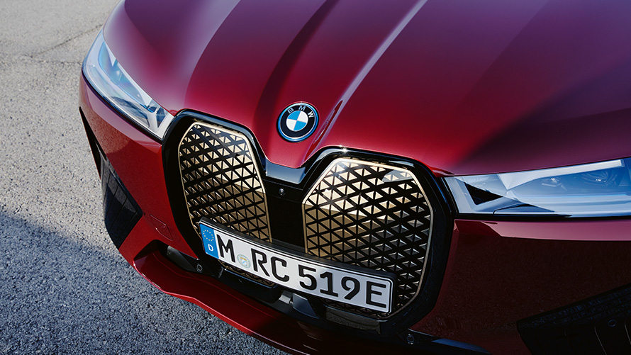 BMW iX i20 električni SUV; BMW iX xDrive50 Shy Tech BMW iX i20 2021 električni SUV; Prikaz prednjeg kraja BMW rešetke Shy Tech BMW-a iX xDrive50 Aventurin Red boje