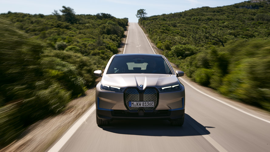 BMW iX pogled sprijeda na cesti BMW iX Cashmere Silver i20 pogled sprijeda na cesti