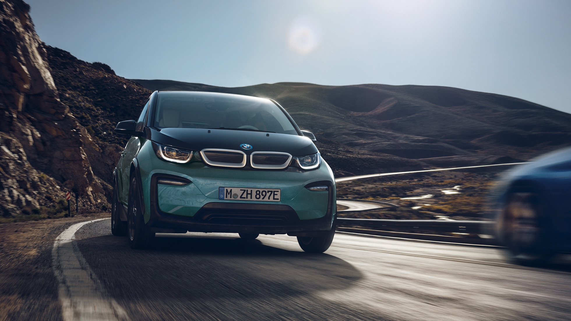 Bočni prikaz BMW-a i3 2018 u vožnji Bočni prikaz BMW-a i3 I01 2018 Jucaro bež boje s Frozen Grey metalik detaljima u vožnji u urbanom okruženju
