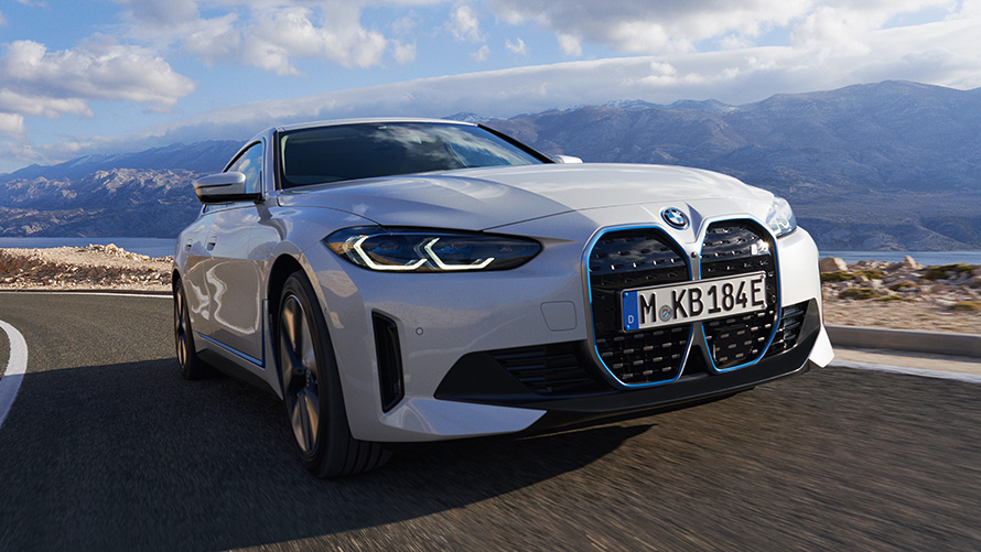 Tročetvrtinski pogled sprijeda BMW i4 eDrive40 G26 2021 u vožnji BMW i4 eDrive40 G26 2021 Mineral White tročetvrtinski pogled sprijeda u vožnji