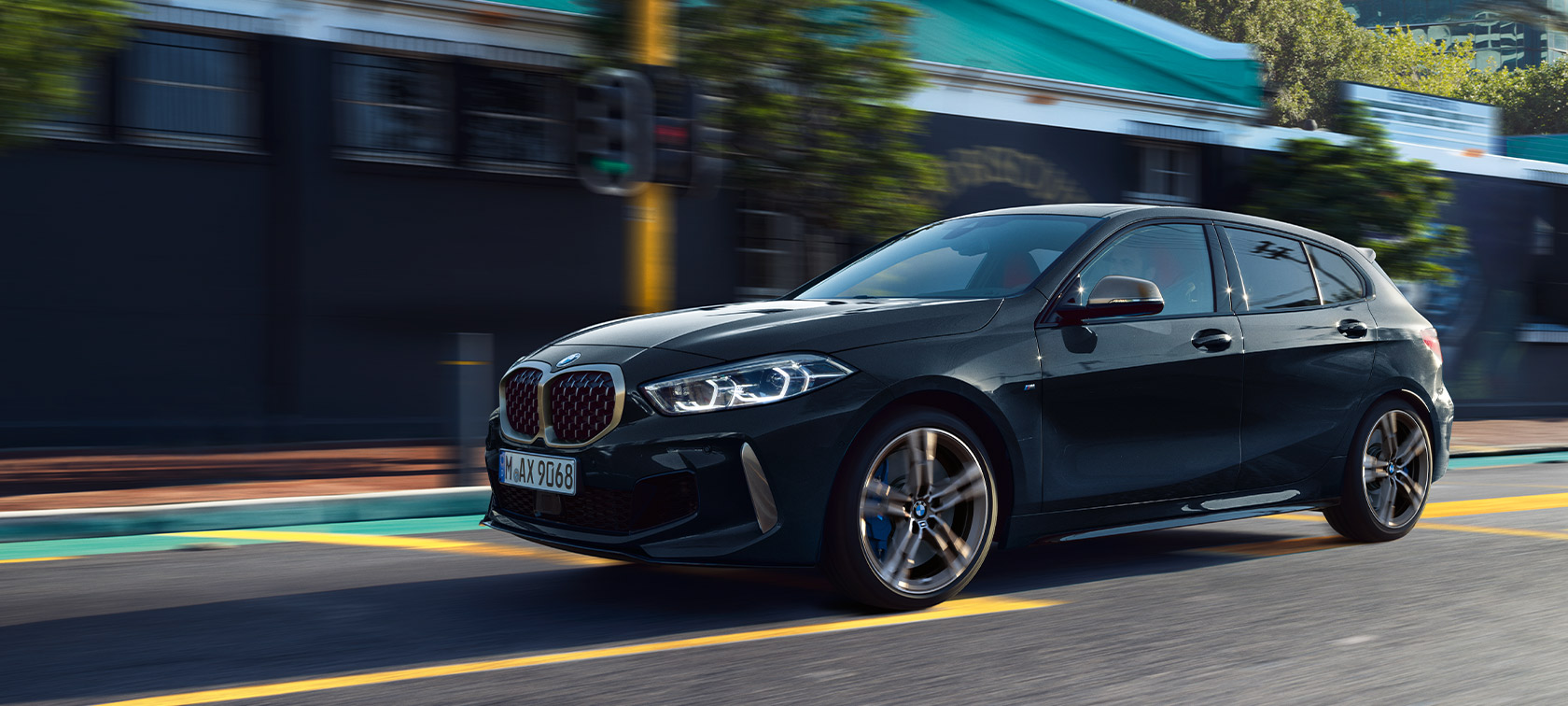 BMW serije 1 M135i xDrive (F40) in Black Sapphire metallic Driving car in urban environment