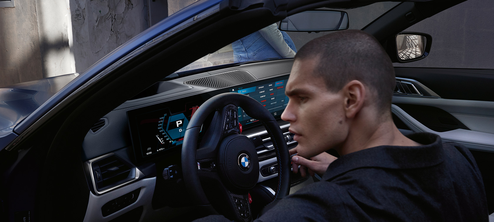 BMW M4 Competition Cabrio sa M xDrive G83 2021 kokpit BMW M4 Competition Cabrio sa M xDrive G83 2021 BMW Individual Frozen Portimao Blue metalik kokpit sa otvorenim vratima i muškim modelom