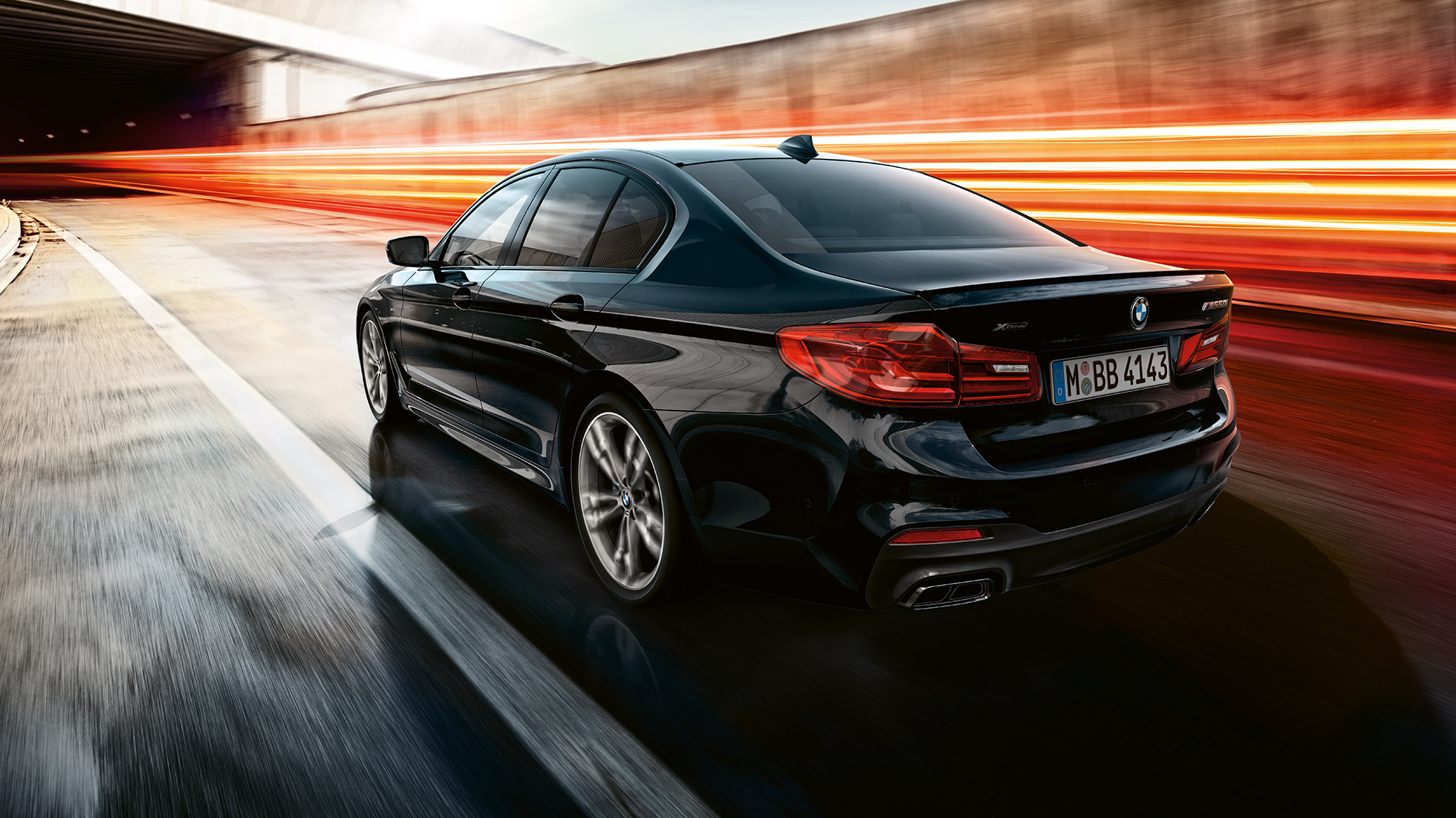 Vozna dinamika. Tročetvrtinski prikaz stražnjeg kraja BMW-a M550i i BMW-a M550d u vožnji.