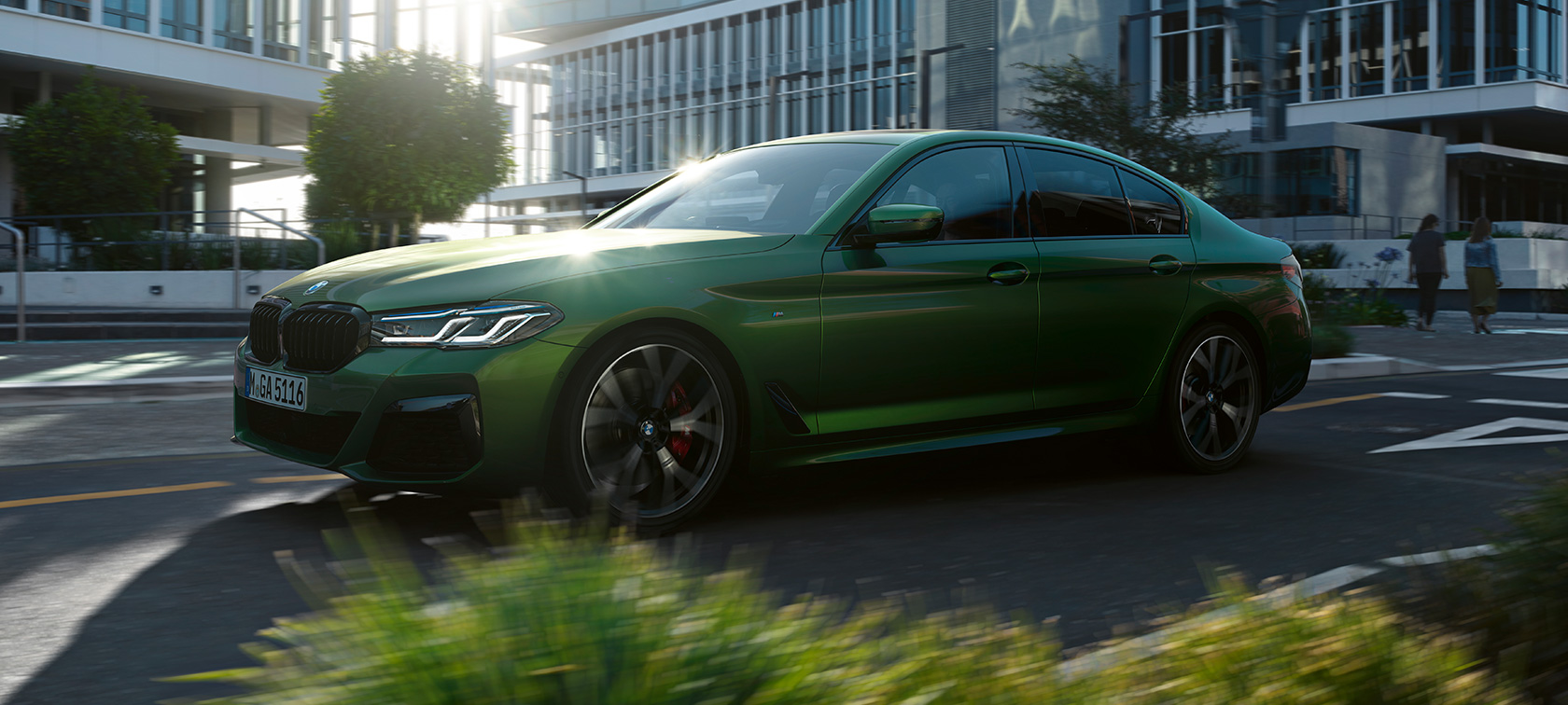 Bočni prikaz BMW-a M550i xDrive Limuzina G30 2020 prilikom vožnje Bočni prikaz BMW-a M550i xDrive Limuzina G30 LCI Facelift 2020 BMW Individual Verde Ermes metalik boje prilikom vožnje