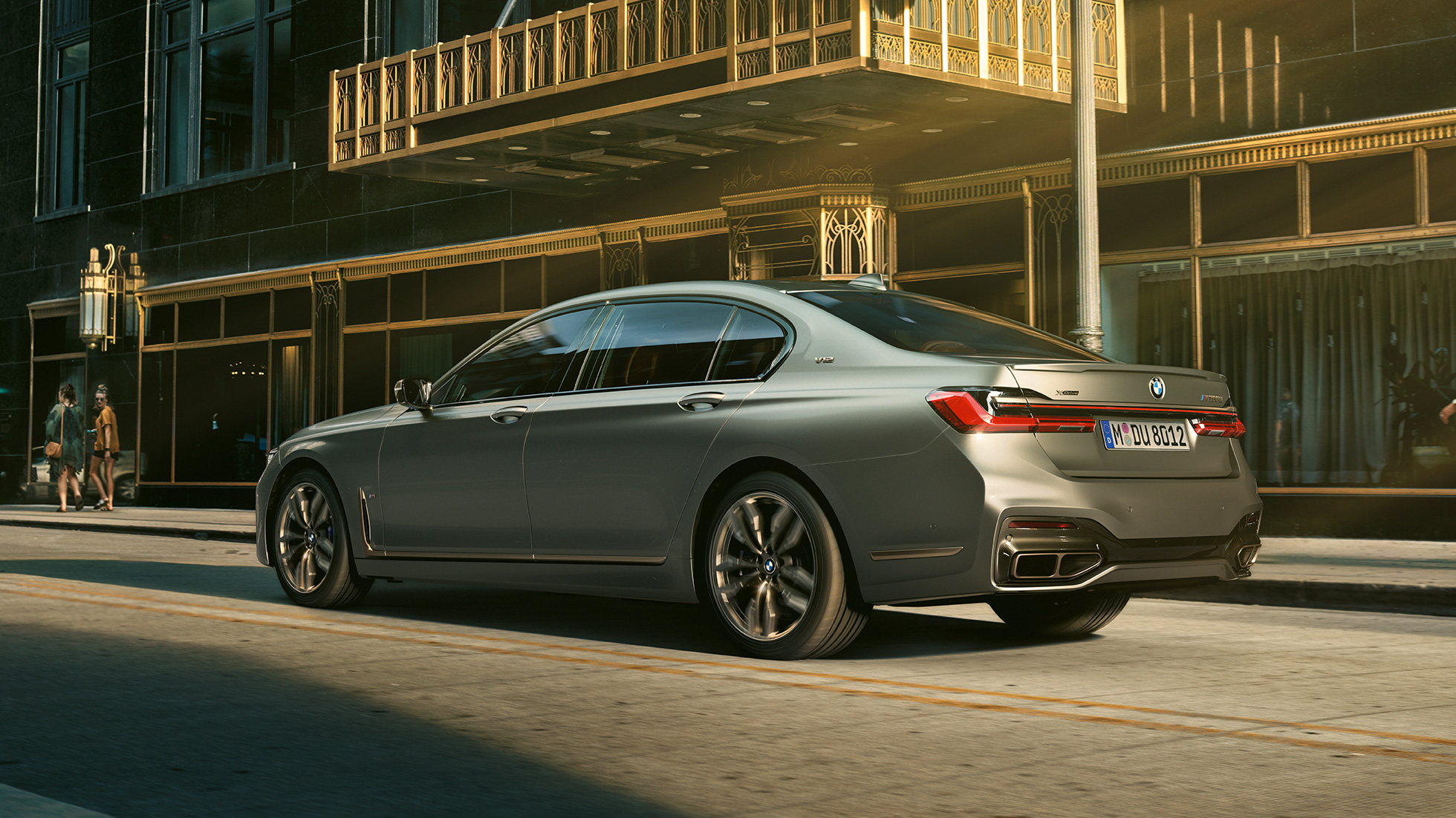BMW M760Li xDrive Limuzina s V12 motorom BMW M760Li xDrive Limuzina, bočni prikaz stražnjeg kraja ispred nebodera u urbanom okruženju