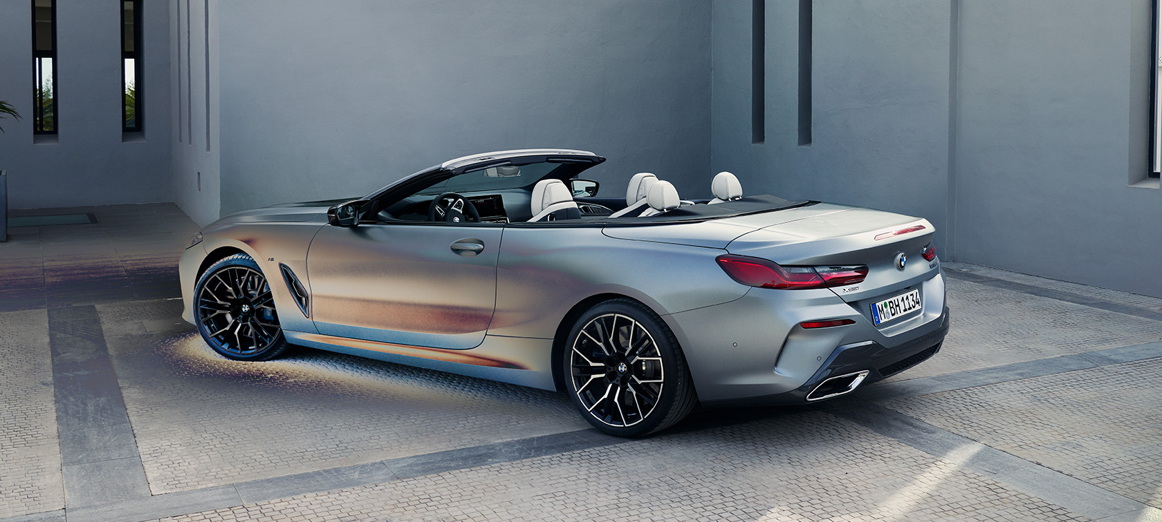 Točetvrtinski pogled straga BMW M850i xDrive Cabrio G14 LCI Facelift 2022 BMW M850i xDrive Cabrio G14 LCI Facelift 2022 BMW Individual Frozen Pure Grey metalik tročetvrtinski pogled straga u mirovanju