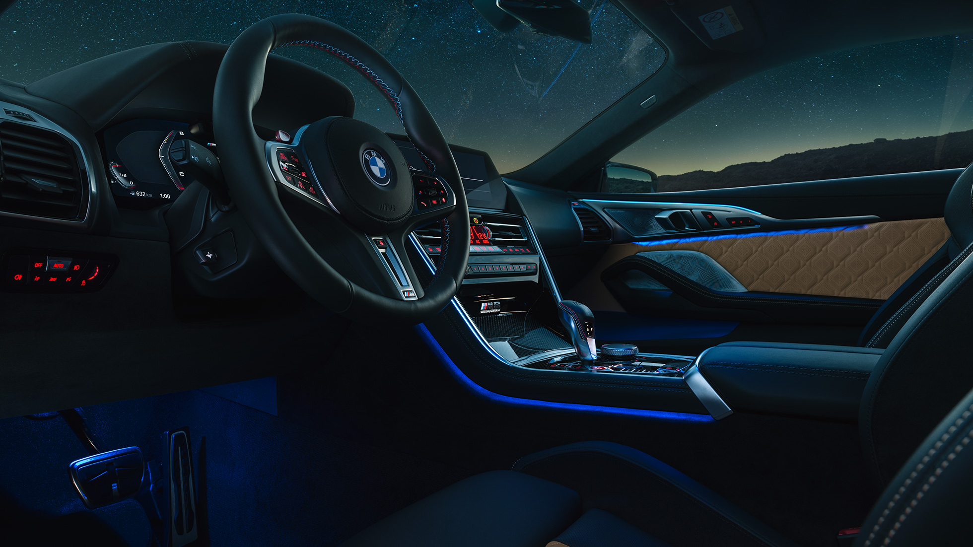 BMW M8 Competition Coupé, unutrašnjost. BMW M8 Competition Coupé, unutrašnjost noću sa M kožnim upravljačem i plavim ambijentalnim osvjetljenjem.