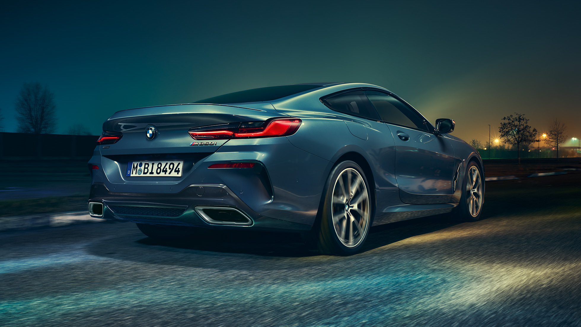 BMW M850i xDrive Coupé, stražnji pogled. BMW M850i xDrive Coupé u Barcelona Blue metalik, stražnji pogled, vožnja noću.