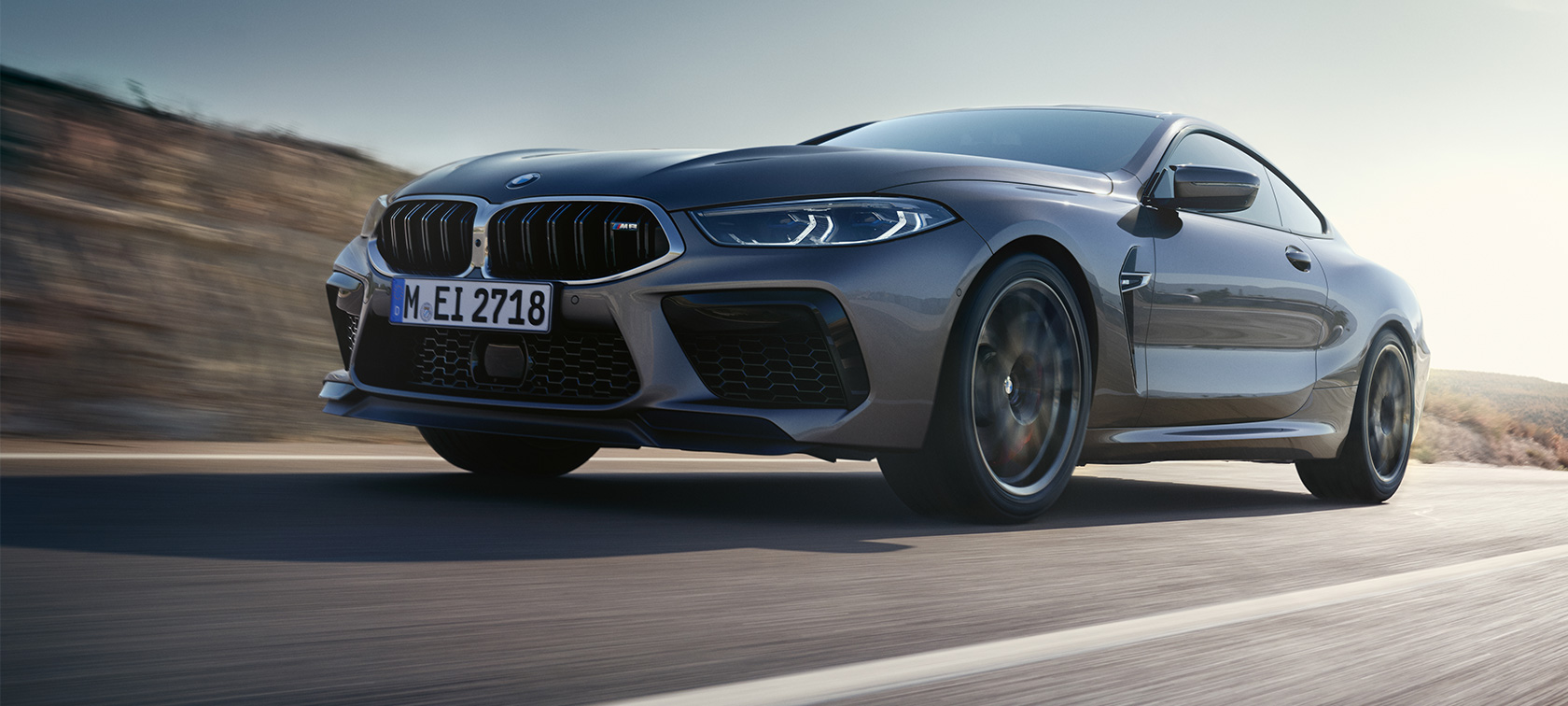 BMW M8 Coupé F92 LCI Facelift 2022 tročetvrtinski pogled s boka u vožnji BMW M8 Coupé F92 LCI Facelift 2022 Skyscraper grey metalik tročetvrtinski pogled s boka iz niskog kuta