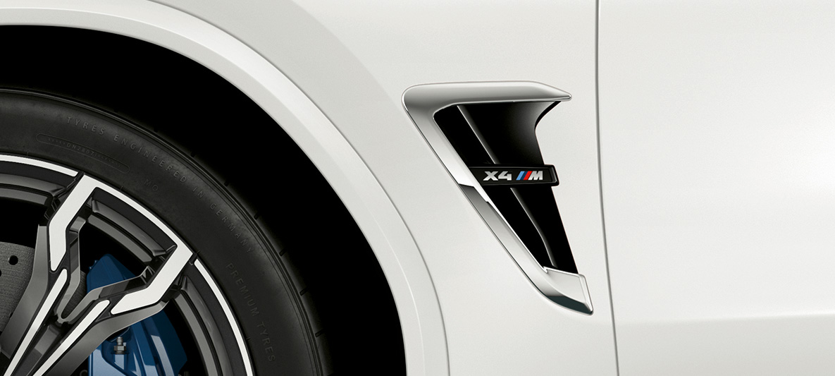 BMW X4 M, M škrge. BMW X4 M u Alpine White boji, vanjština, M škrge s kormiranim značajkama i oznakom modela.