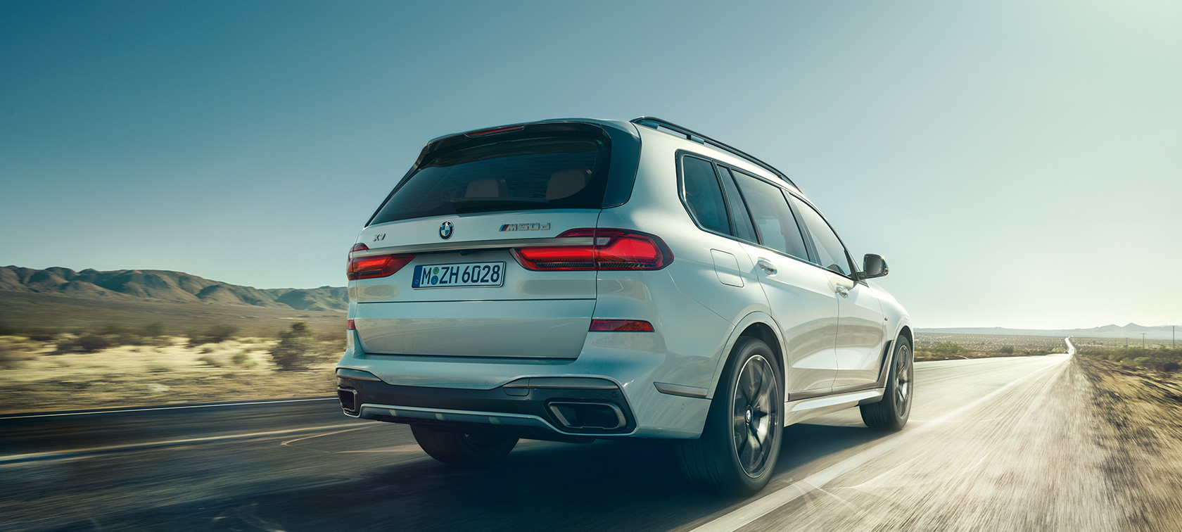 BMW X7 M50d , prikaz stražnjeg kraja BMW X7 M50d u Mineral White boji, u vožnji na praznoj autocesti, prikaz stražnjeg kraja, G07, 2019