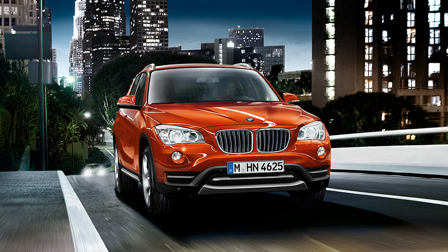 Tročetvrtinski prikaz prednjeg kraja BMW-a X1 E84 prve generacije na ulici BMW serije X; Tročetvrtinski prikaz prednjeg kraja BMW-a X1 E84 prve generacije na ulici