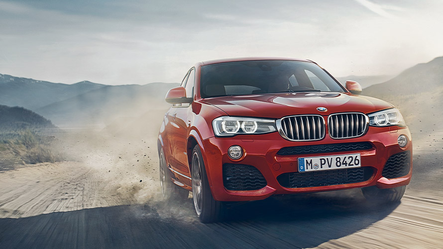 Tročetvrtinski prikaz prednjeg kraja BMW-a X4 F26 prve generacije u vožnji BMW serije X; Tročetvrtinski prikaz prednjeg kraja BMW-a X4 F26 prve generacije u vožnji