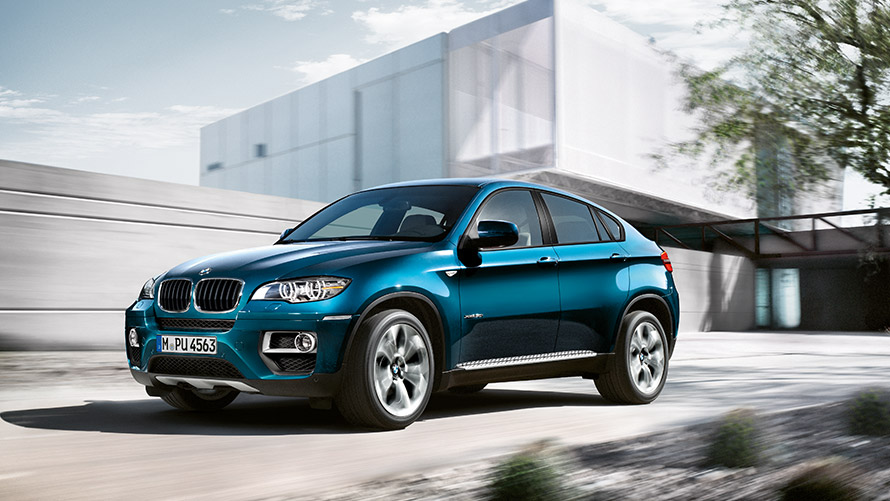 Tročetvrtinski bočni prikaz BMW-a X6 E71 prve generacije ispred zgrade BMW serije X; Tročetvrtinski bočni prikaz BMW-a X6 E71 prve generacije ispred zgrade