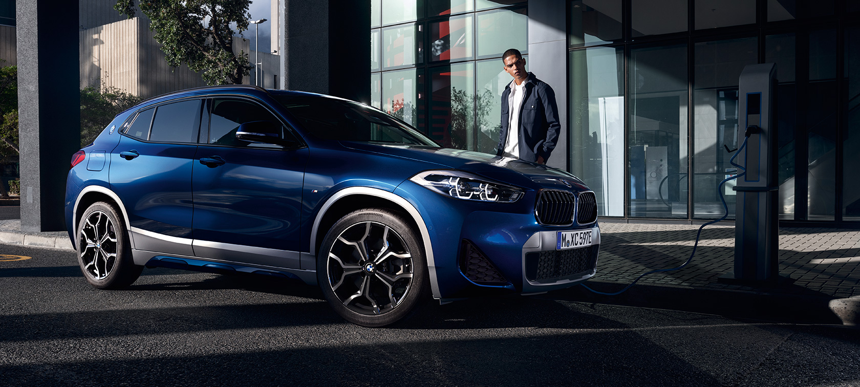 Tročetvrtinski bočni prikaz plug-in hibrida BMW-a X2 xDrive25e F39 na napajanju s modelom Tročetvrtinski bočni prikaz plug-in hibrida BMW-a X2 xDrive25e F39 na napajanju s modelom