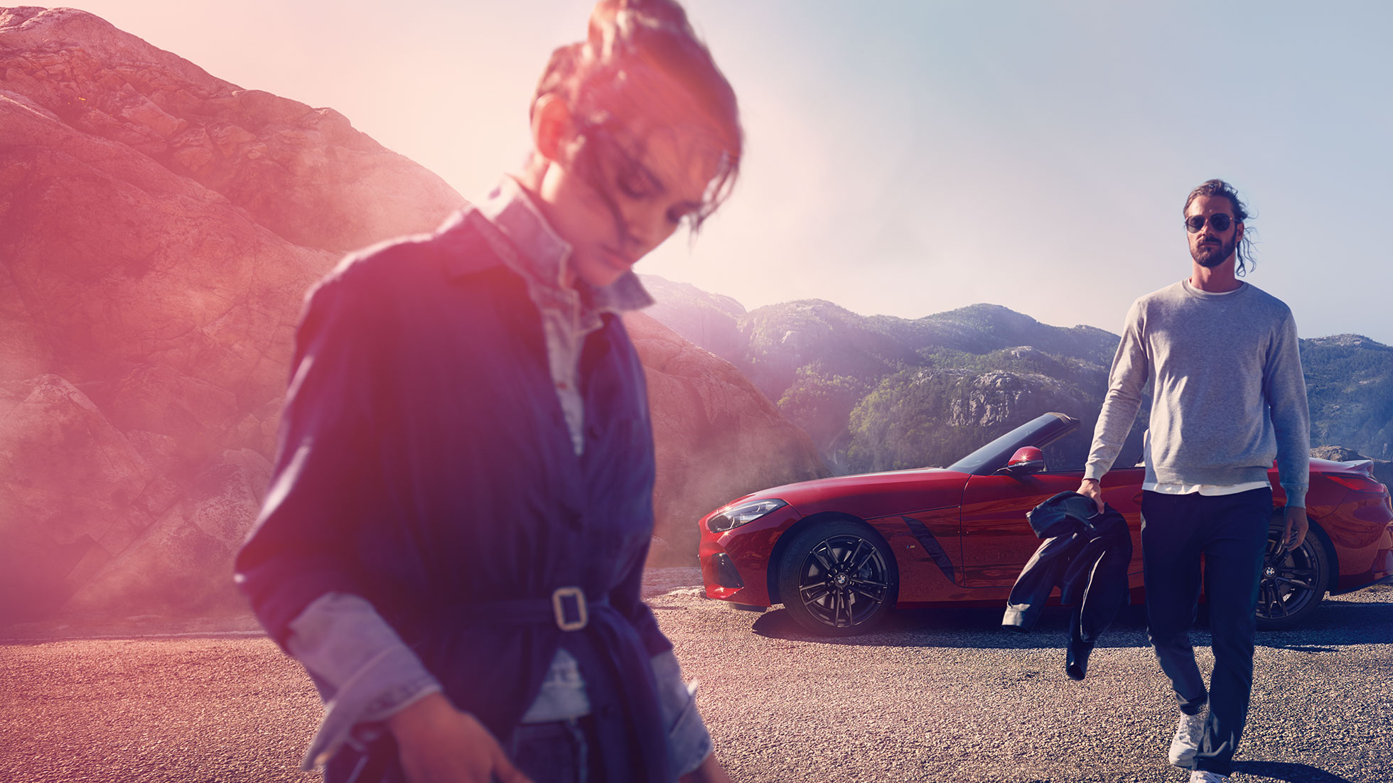 BMW Z4 Roadster ispred planinske pozadine Muškarac i žena i BMW Z4 Roadster ispred planinske pozadine