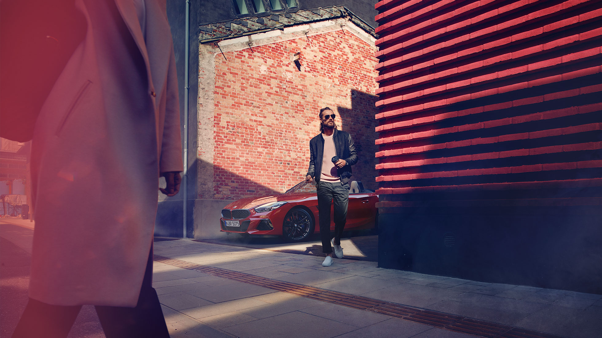 BMW Z4 Roadster u sporednoj ulici Muškarac u sporednoj ulici ispred BMW-a Z4 Roadster