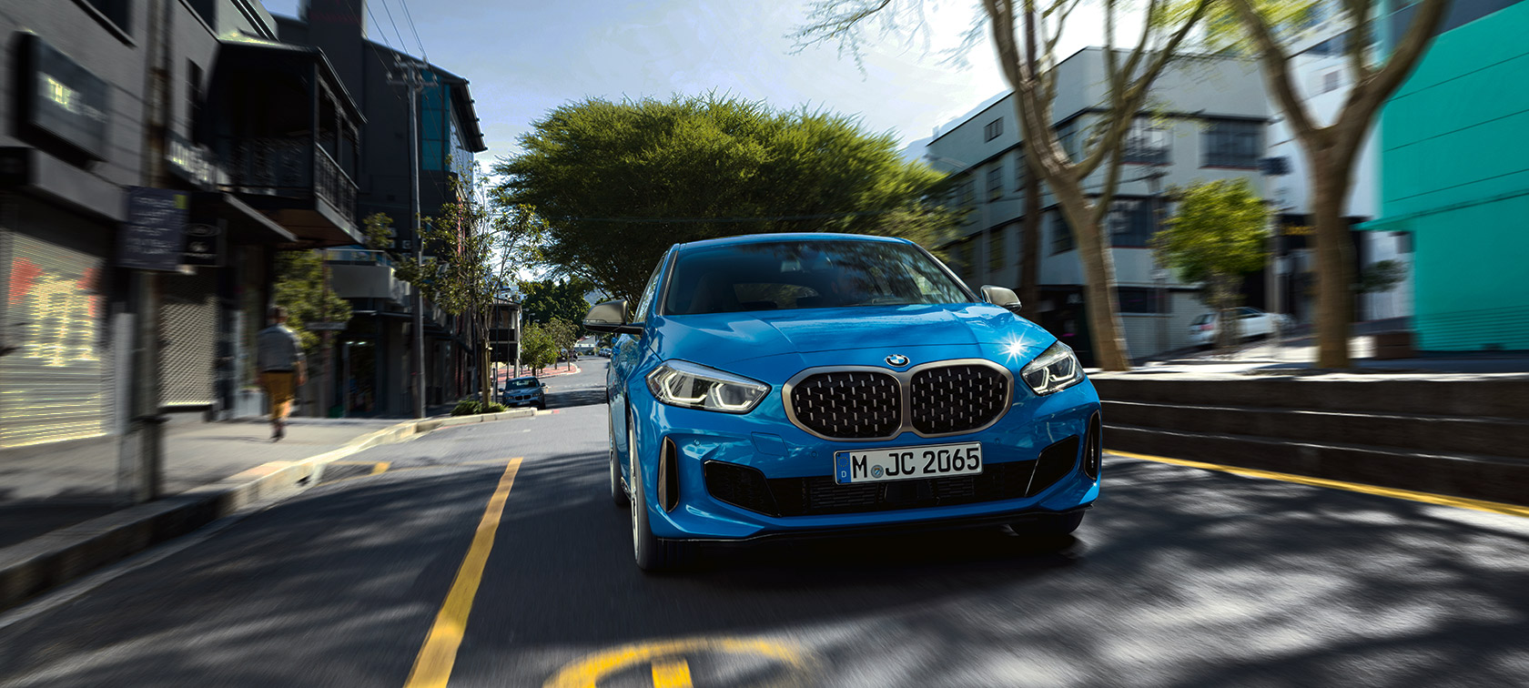 BMW serije 1 u Misano Blue metalik boji, prikaz prednjeg kraja prilikom vožnje.