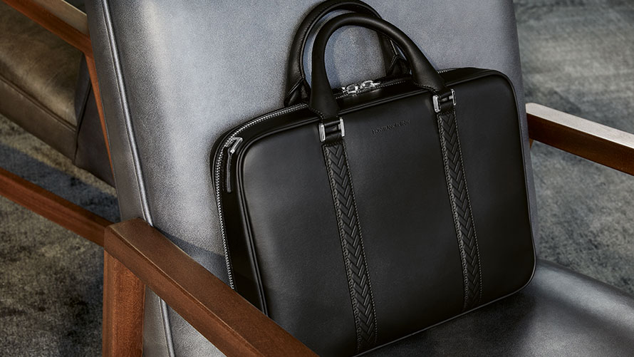 Montblanc BMW torba za dokumente. Slika prikazuje Montblanc BMW torbu za dokumente naslonjenu na rukohvat stolice.