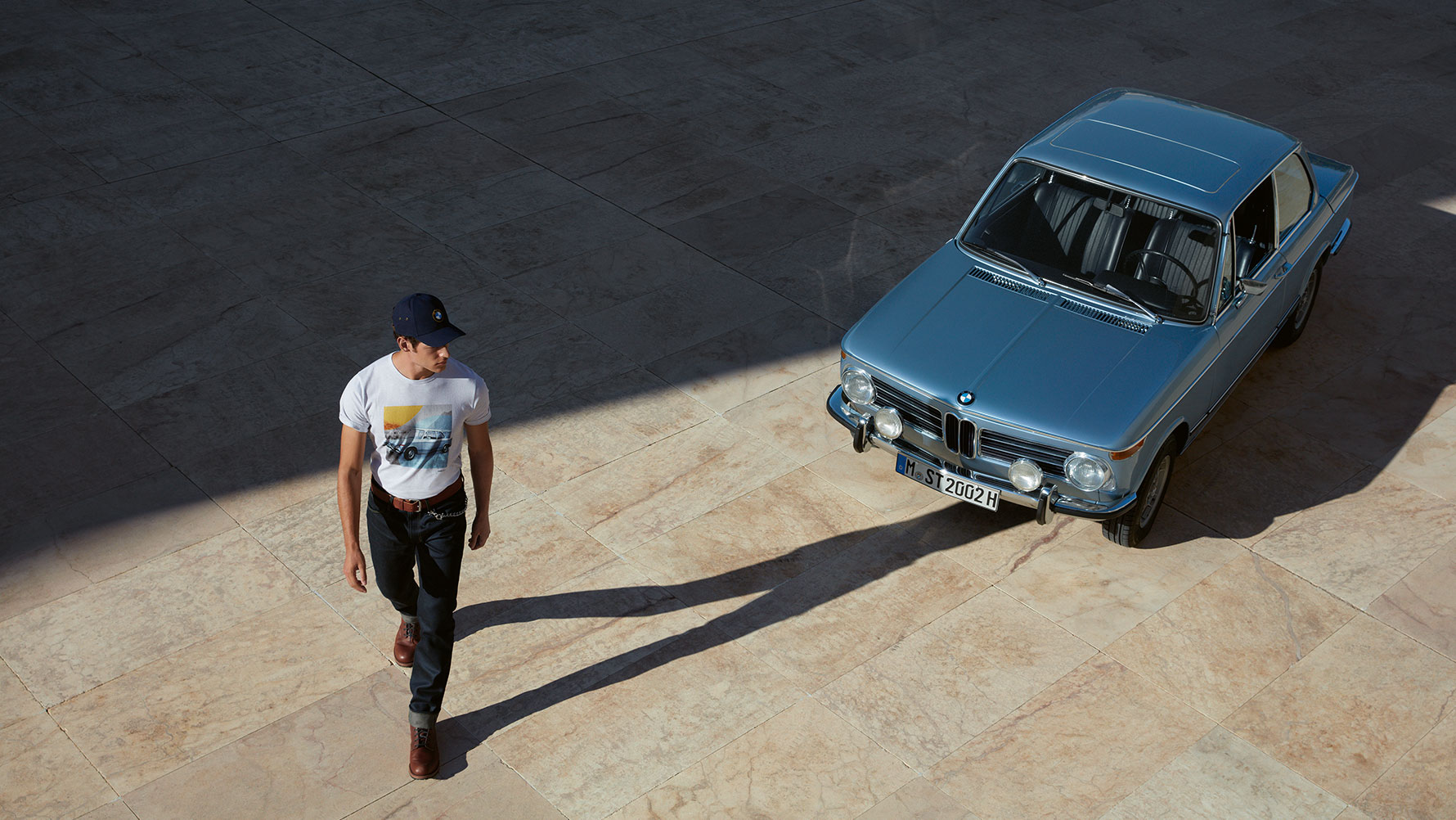 Prikazan je muškarac koji nosi BMW Classic mušku majicu i kako se divi klasičnom BMW-u. Prikazan je muškarac koji nosi BMW Classic mušku majicu i kako se divi klasičnom BMW-u.