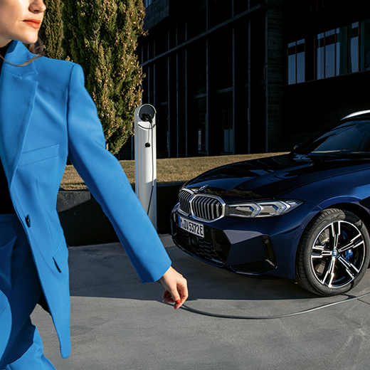 Situacija punjenja s BMW-om u prvom planu žena koja hoda