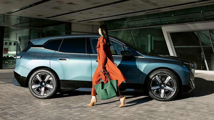 Prednost BMW digitalnog ključa Prednost BMW digitalnog ključa BMW iX i20 Pogled sa strane sa ženom u prvom planu