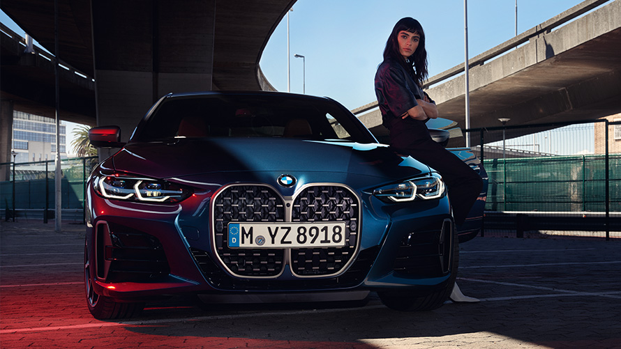 Ženska osoba se naginje na BMW serije 4 Coupé Remote Software Upgrade Ženska osoba se naginje na BMW serije 4 Coupé
