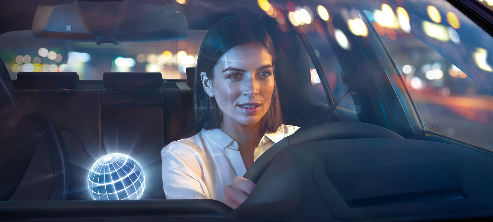 BMW Intelligent Personal Assistant Žena koja se vozi u BMW-u u noćnom okruženju
