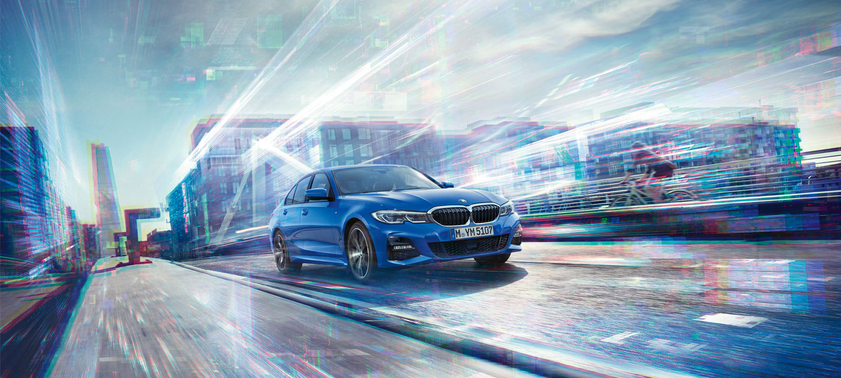 BMW serije 3 Limuzina, prednji prikaz. Prednji prikaz BMW-a serije 3 Limuzine u vožnji po danu ispod staklene zgrade.