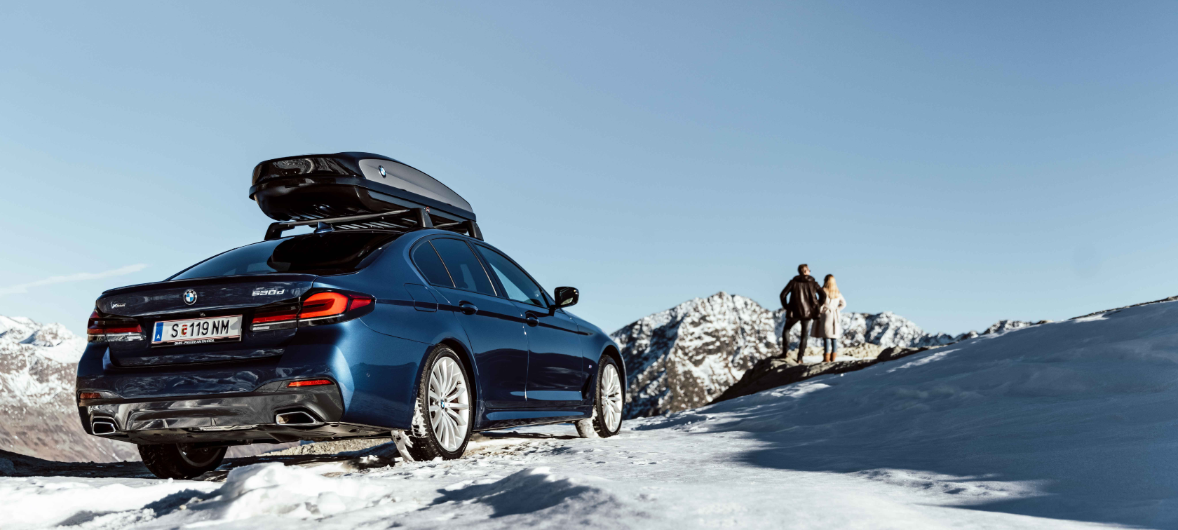 Originalni BMW dodaci i BMW servis za jesen i zimu Žena i muškarac se smiju na gumama u snijegu