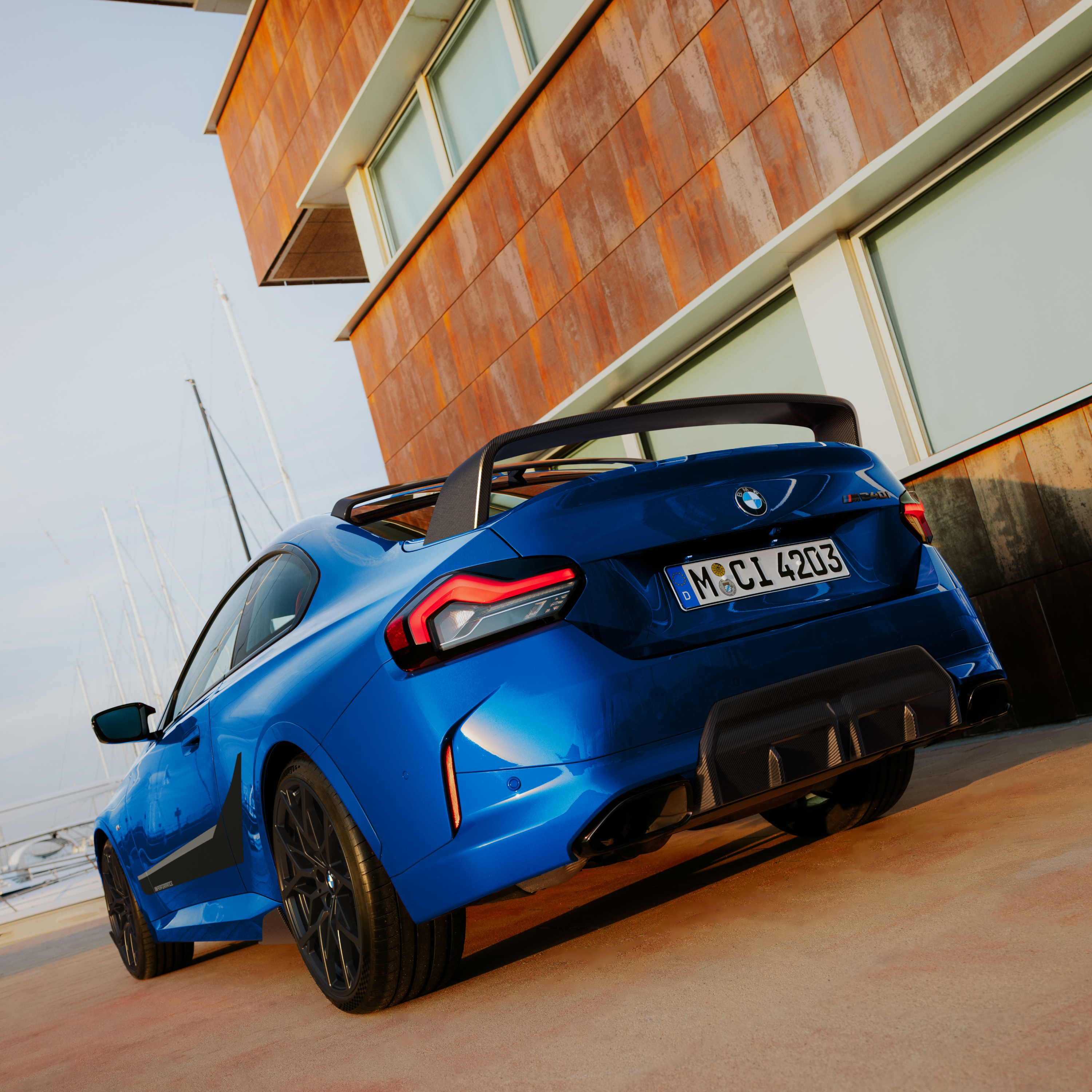 BMW s M Performance stražnjim spojlerom parkiran ispred kuće